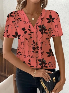 Dettaglio del top a maniche corte corallo con scollo a V e fantasia floreale nera