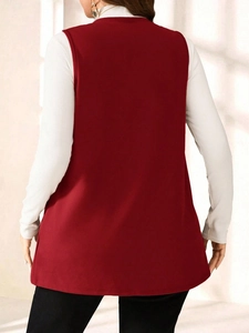 Back view of a long burgundy sleeveless vest styled over a white turtleneck sweater
