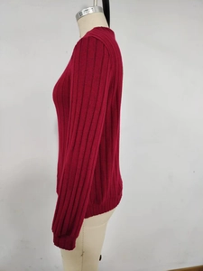 Detail view of burgundy slim-fit rib-knit sweater with long sleeves on white mannequin