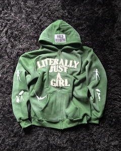 Detail of dark green Y2K hoodie featuring white applique embroidery and graphic prints