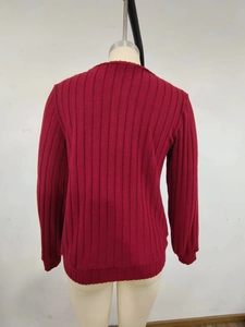 Detail view of the back of a burgundy ribbed knit sweater with long sleeves and round neck