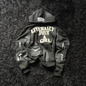 Black Y2K zip-up hoodie featuring white 3D letter print and female silhouette graphics