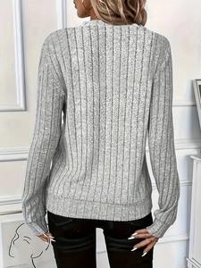 Detail of light grey ribbed knit fabric texture on a long sleeve fitted sweater for women