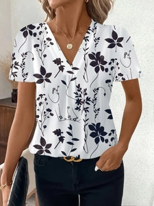 Dettaglio del top bianco con scollo a V e stampa floreale nera indossato da una modella