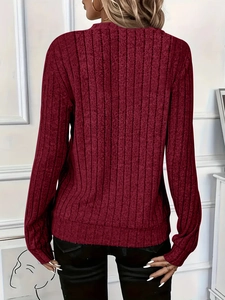 Detail view of the ribbed texture and fitted back of a burgundy long-sleeve knit sweater