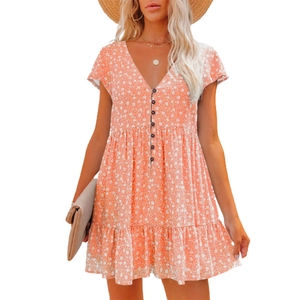 Detail of coral orange floral dress with V-neckline and decorative front buttons