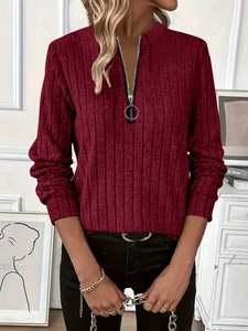 Detail of dark red ribbed knit sweater featuring a stylish metal ring zipper and stand collar