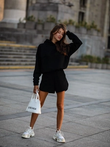 Close-up of a black long-sleeve hoodie and matching high-waisted shorts set for women