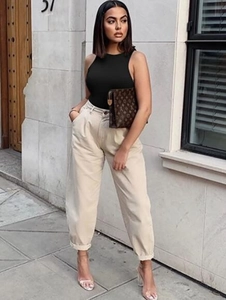 Street style view of a black sleeveless bodycon top paired with beige wide-leg trousers