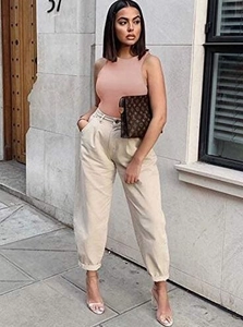 Street style view of beige high-waisted harem pants with rolled cuffs and cotton twill fabric