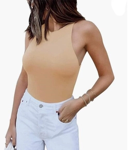 Detail of beige sleeveless racerback bodysuit paired with white denim and gold jewelry