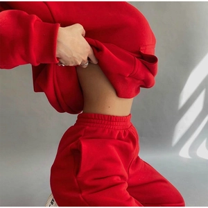 Detailed close-up of vibrant red hooded sweatshirt and matching jogger pants set