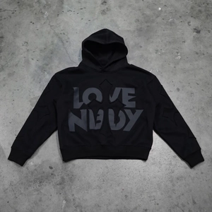 Detailed close-up of the grey LOVE NEEDY cross print on a black oversized hoodie
