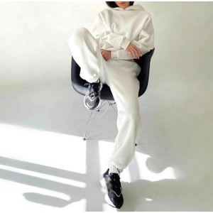 Detail of white cotton tracksuit set featuring oversized hoodie and joggers in studio