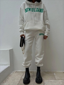 Detail des weißen Fleece-Trainingsanzugs mit dunkelgrünem New Orleans Vintage-Schriftzug