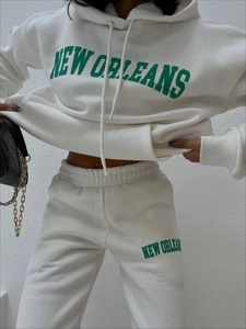 Detail von weißem Kapuzenpullover-Set mit grüner New Orleans Aufschrift und weichem Fleece