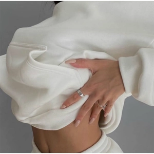 Detail of ribbed cuffs and heavy cotton fabric on a white hoodie and joggers set