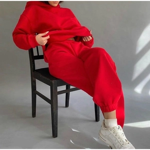 Detail of red oversized hoodie and joggers set shown on model in studio setting