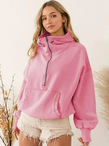 Detail of pink half-zip hoodie featuring a kangaroo pocket and adjustable drawstring hood