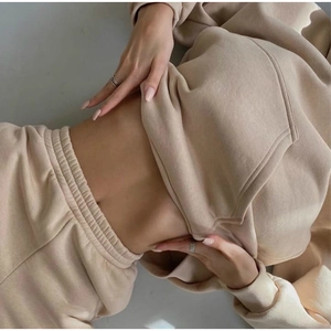 Close-up of beige cotton fleece hoodie and drawstring joggers with ribbed cuffs