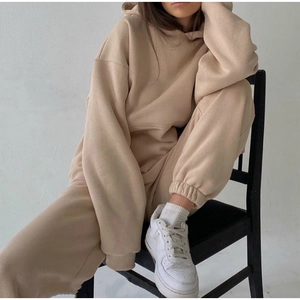 Detail of soft beige knit fabric on a women's oversized hoodie and joggers tracksuit set