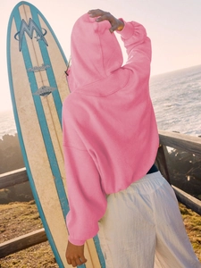 Back view of pink zip-up hoodie with drawstring and white casual sports pants