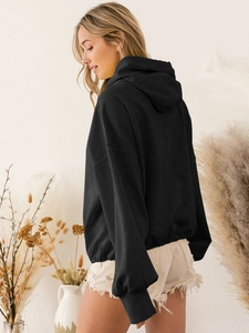 Detail view of black oversized hooded sweatshirt with ribbed cuffs and drop shoulder seam