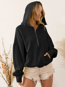 Detail of oversized black hoodie with half-zip, ribbed cuffs and kangaroo pocket for women