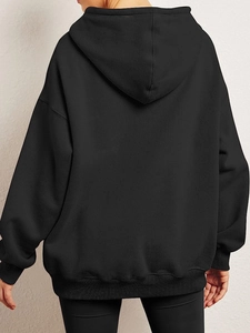 Rear view of a black oversized hoodie featuring a dropped shoulder design and ribbed hem