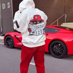 Street style view of a white hoodie with cartoon back print and red corduroy pants
