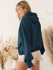 Detail of dark blue oversized hoodie featuring dropped shoulders and ribbed cuffs