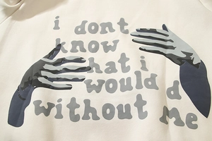 Detail of artistic hand graphic and text print on cream oversized hoodie fabric