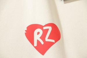 Detail of red heart puff print and RZ letters on off-white heavy cotton hoodie fabric