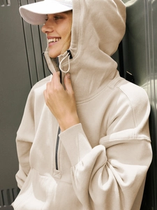 Detail of light beige zip-up hoodie showing thick cotton texture and ribbed cuffs