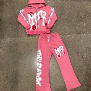 Detail von pinkfarbenem Y2K Hoodie und Hose mit Graffiti-Text und rotem Smiley-Aufdruck