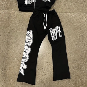 Detail einer weiten schwarzen Y2K-Jogginghose mit Graffiti-Schriftzug und weißem Tunnelzug