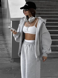 Detailansicht von grauem Oversize-Kapuzenpullover und Jogginghose mit weißem Crop-Top