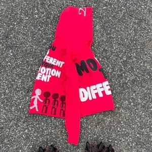 Detail of red oversized hoodie featuring black and white graffiti print and bold lettering