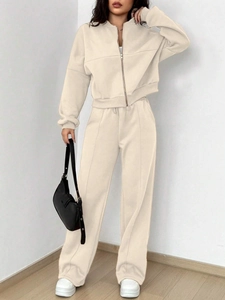 Detail view of the fine knitted fabric and pleated seam on beige two-piece sports tracksuit