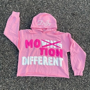 Detail of pink hoodie with foam print text and raw edge hem on asphalt background