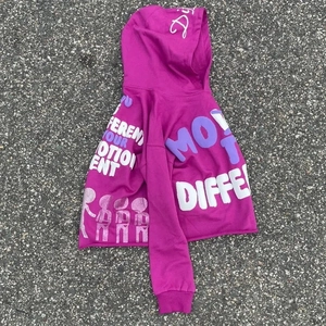 Detail of purple cropped hoodie showing 3D foam puff print letters and ribbed cuffs