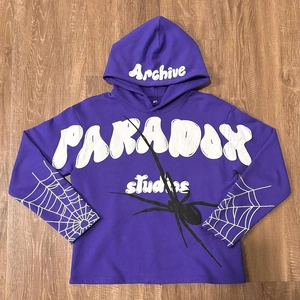 Detail of purple hoodie featuring 3D foam lettering and classic spider web graphic