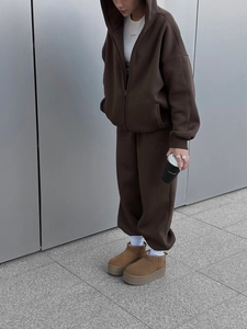 Seitenansicht des schokobraunen Kapuzenanzugs mit Plateau-Boots im Streetstyle-Look