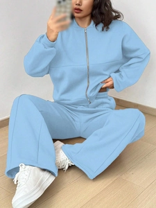 Detail of light blue zip-up sweatshirt set featuring drawstring wide-leg pants in soft cotton