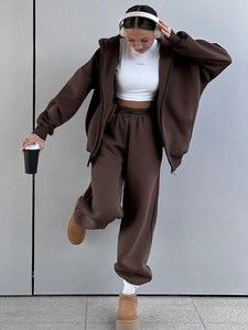 Detail eines dunkelbraunen Oversized-Jogginganzugs mit Kapuzenjacke und Sporthose