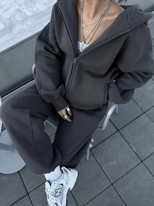 Detail eines dunkelgrauen Oversized-Hoodies mit Reißverschluss und passender Jogginghose