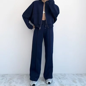 Detail view of navy blue hooded zip-up crop top and wide-leg drawstring trousers set