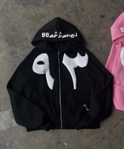 Detailed view of Y2K streetwear zip hoodie with white graphic patches and puff print