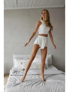 White ribbed two-piece lounge set with cropped tank top and ruffled hem shorts for women