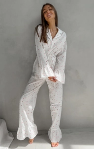 Détail d'un pyjama en coton blanc avec imprimés cœurs rouges et volants aux poignets